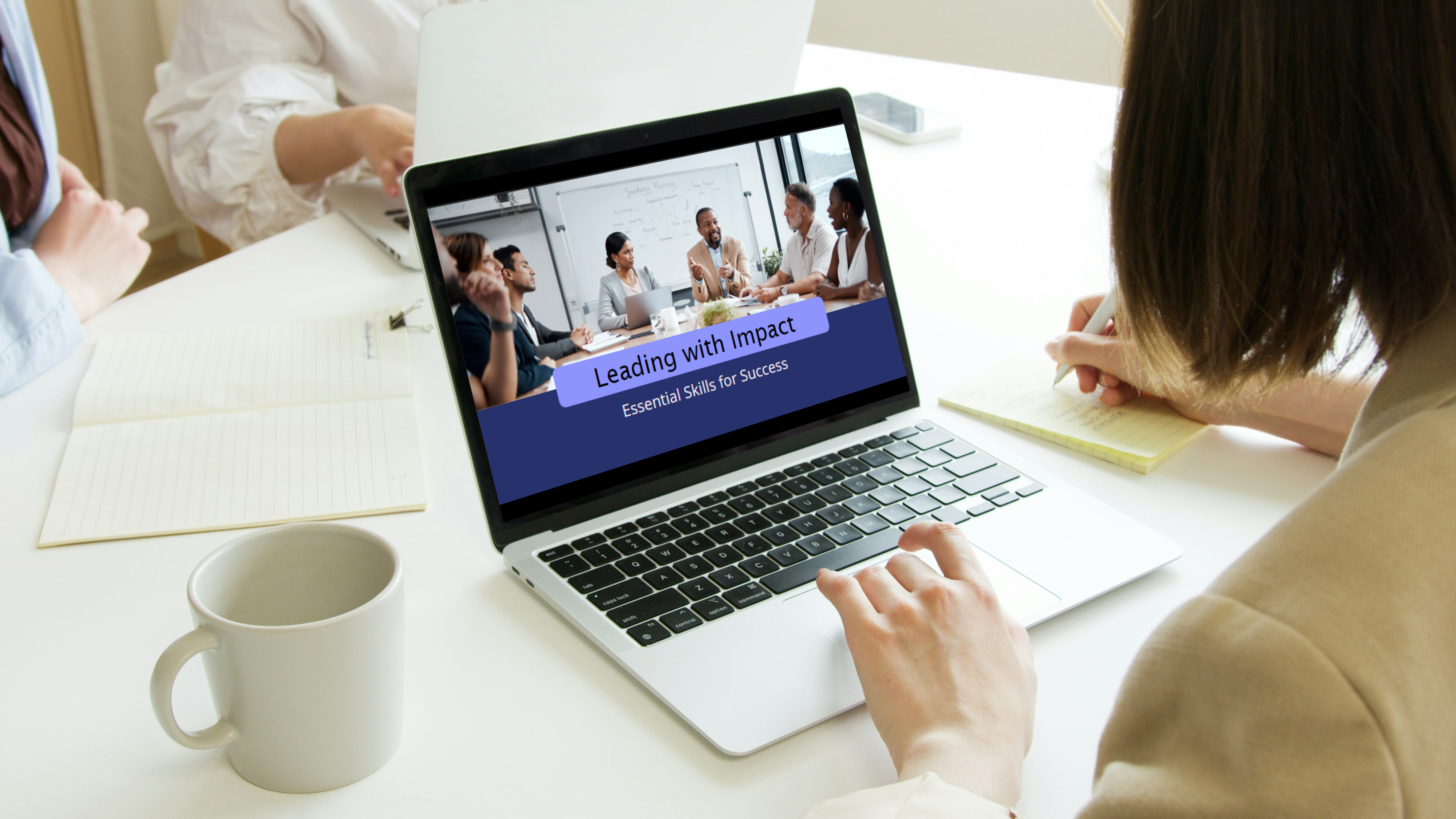 an employee takes a course on the computer. The course is called, "Leading with Impact. Essential Skills for Success."